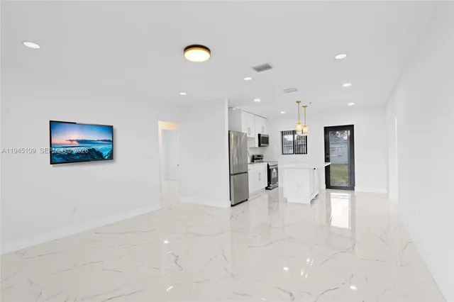 a view of kitchen with kitchen island stainless steel appliances refrigerator stove microwave and cabinets