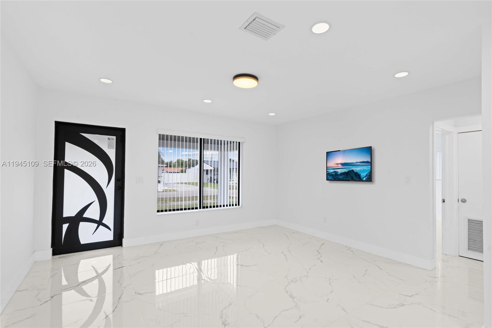 3030 Northwest 99th Street Miami, FL 33147 - Photo 7 of 27 a view of an empty room with a window and furniture