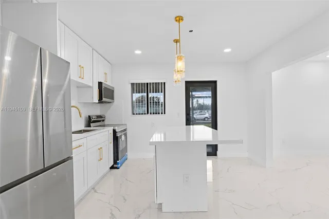 a kitchen with stainless steel appliances a refrigerator sink and microwave