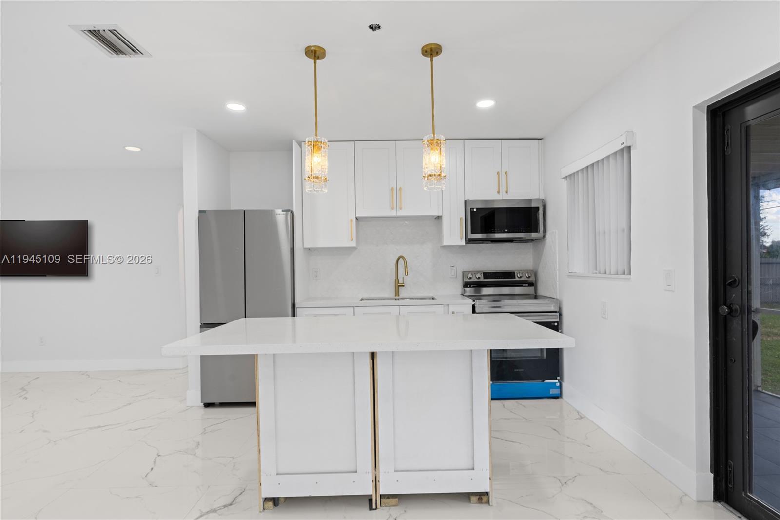 3030 Northwest 99th Street Miami, FL 33147 - Photo 10 of 27 a kitchen with stainless steel appliances a refrigerator sink and microwave