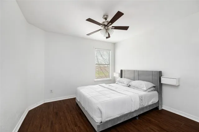 a bedroom with a large bed and a ceiling fan