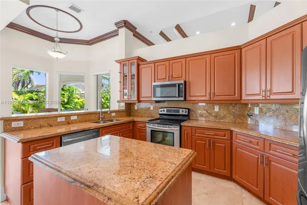 a kitchen with stainless steel appliances granite countertop a sink stove and microwave