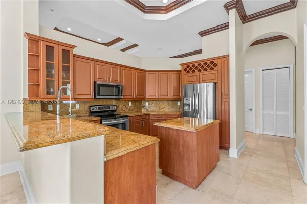 a kitchen with stainless steel appliances granite countertop a refrigerator a stove top oven a sink and dishwasher