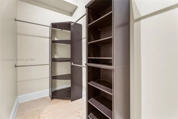 a view of walk in closet with empty racks