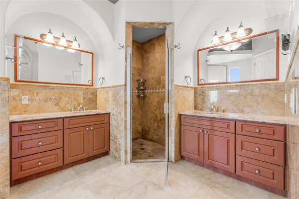 a bathroom with a granite countertop double vanity sink mirror and