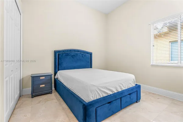 a bed sitting in a bedroom next to a window