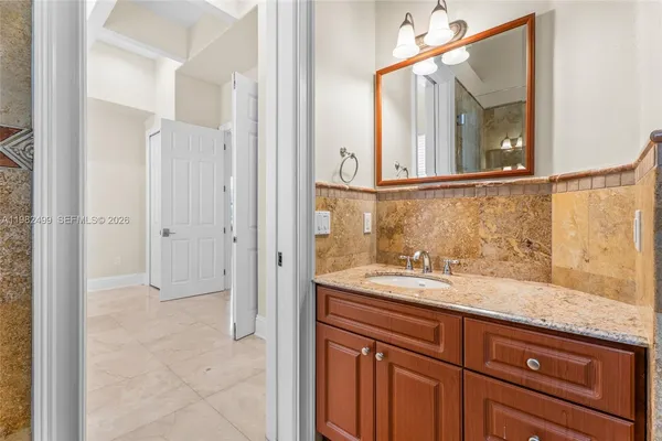a bathroom with a granite countertop sink and a mirror