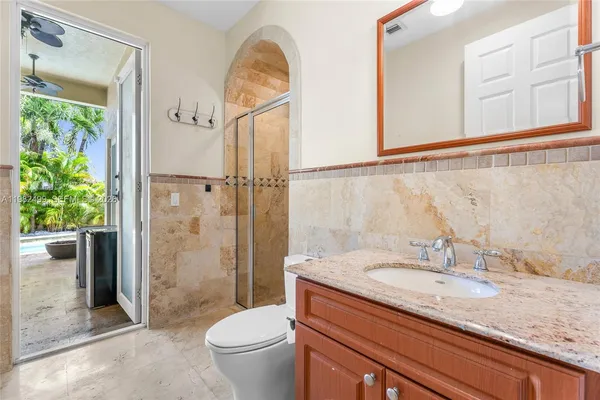 a bathroom with a granite countertop sink a toilet and shower