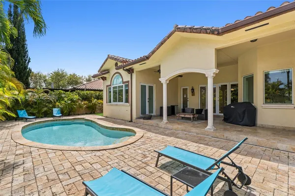 a view of a house with pool and sitting area