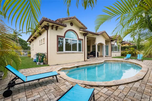 a view of a house with swimming pool and sitting area