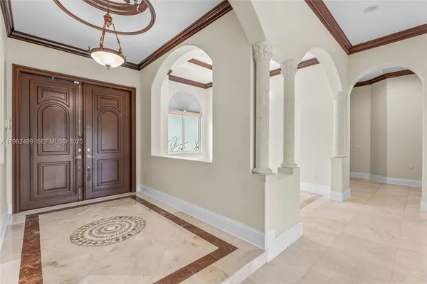 a view of a hallway with windows and chandelier