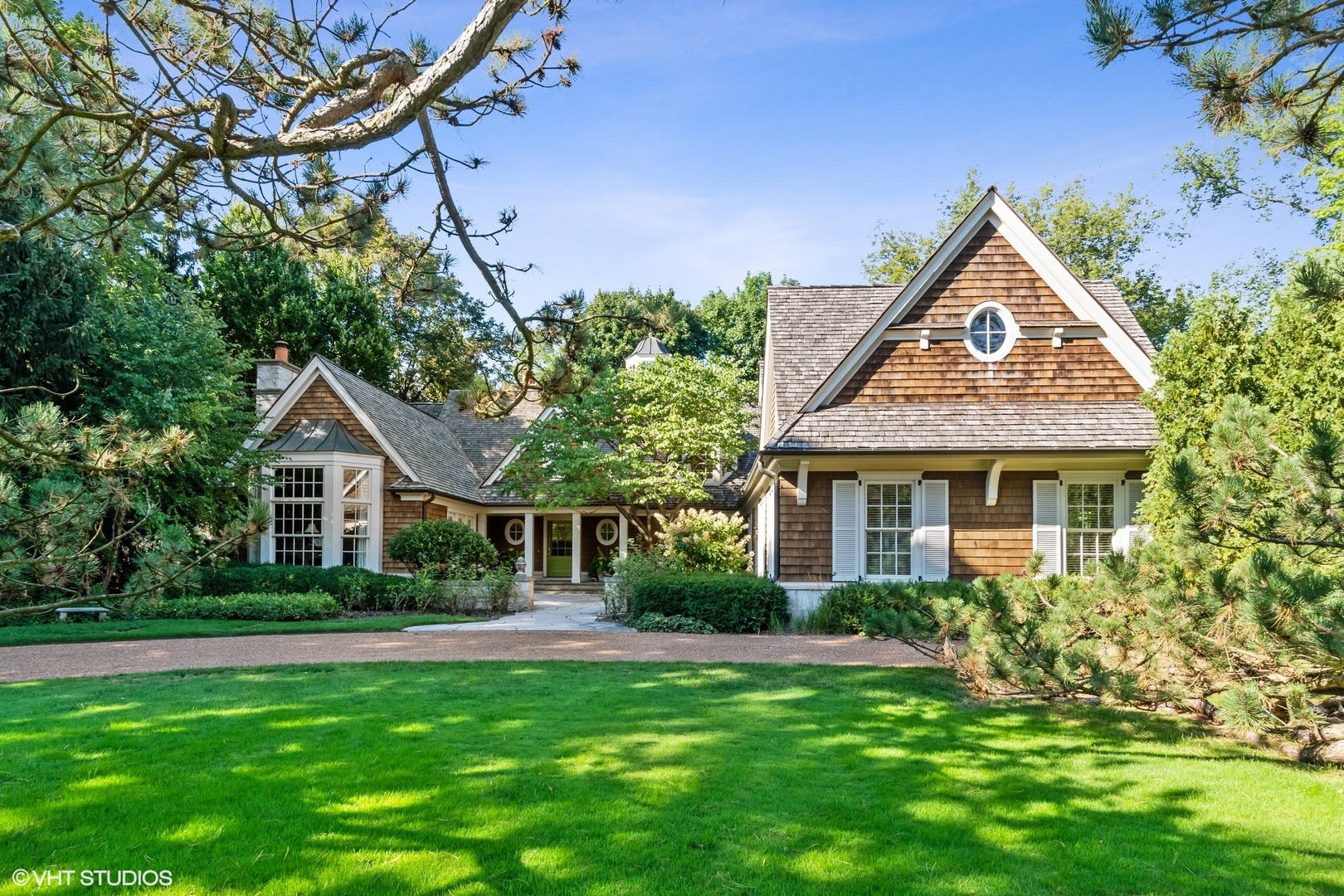 a front view of a house with a yard and potted plants