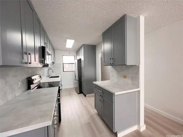 a kitchen with stainless steel appliances granite countertop a sink a stove and a refrigerator