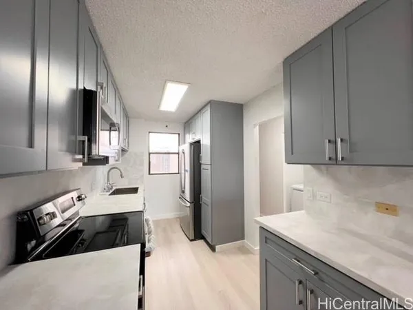 a kitchen with stainless steel appliances kitchen island granite countertop a refrigerator and a sink