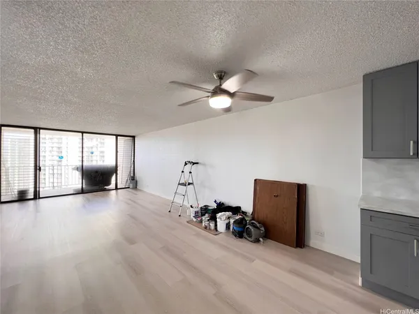 a view of a livingroom with wooden floor and a ceiling fan