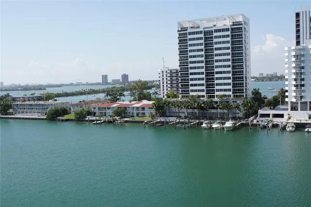 an aerial view of ocean and residential houses with outdoor space