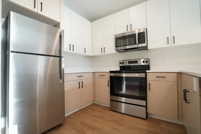 a kitchen with stainless steel appliances and wooden cabinets