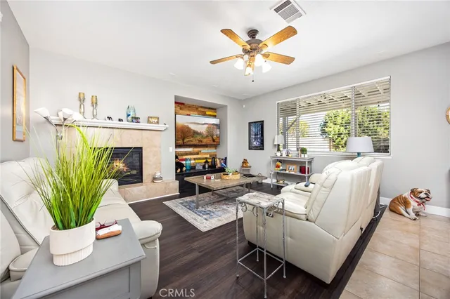 a living room with furniture a fireplace a potted plant and a large window