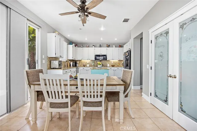 a dining room with stainless steel appliances kitchen island granite countertop a dining table and chairs