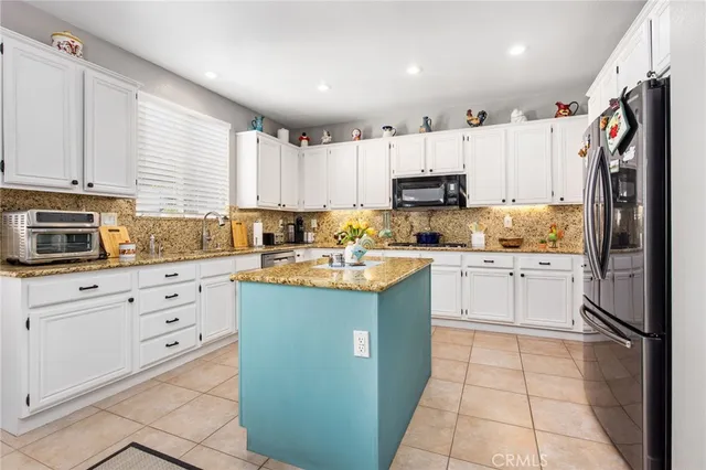 a kitchen with cabinets a window and stainless steel appliances