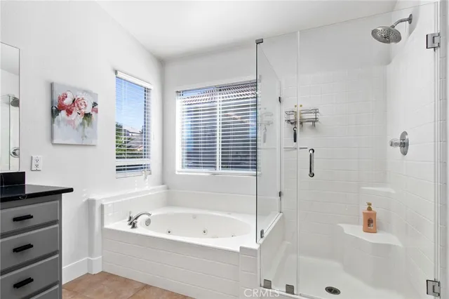 a bathroom with a bathtub a shower a sink and a window