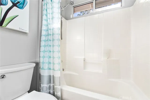 a white toilet sitting next to a bath tub