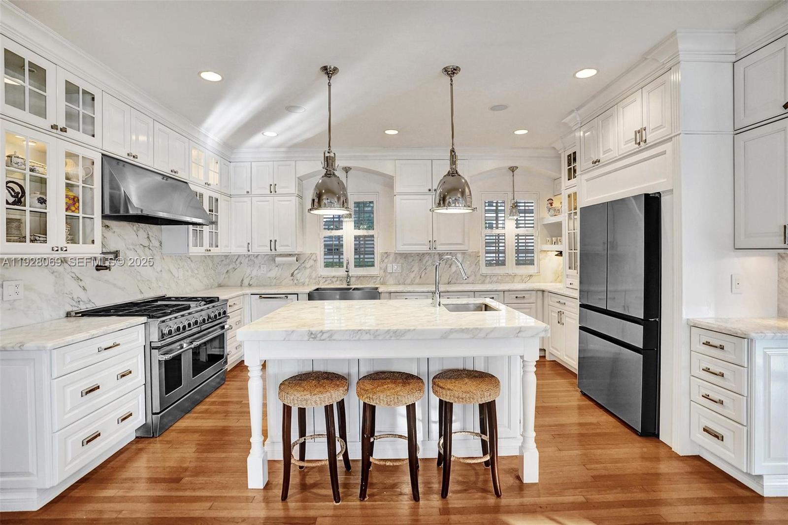 1281 Banyan Road Boca Raton, FL 33432 - Photo 32 of 69 a kitchen with stainless steel appliances kitchen island granite countertop a stove a refrigerator a oven and white cabinets with wooden floors
