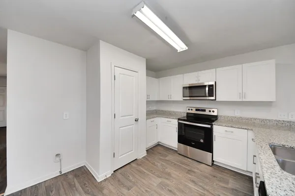 a kitchen with stainless steel appliances a sink cabinets and wooden floor