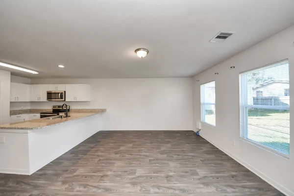 a view of kitchen with wooden floor and electronic appliances