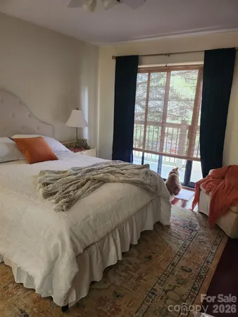 a bedroom with bed and large windows