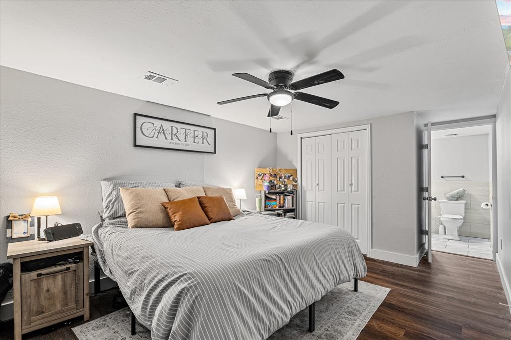 25 West Parnell Street Denison, TX 75020 - Photo 11 of 16 a bedroom with a large bed and a chandelier