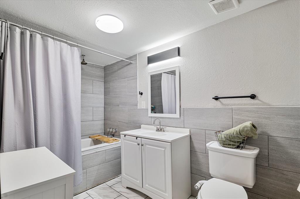 25 West Parnell Street Denison, TX 75020 - Photo 12 of 16 a bathroom with a sink mirror vanity and toilet