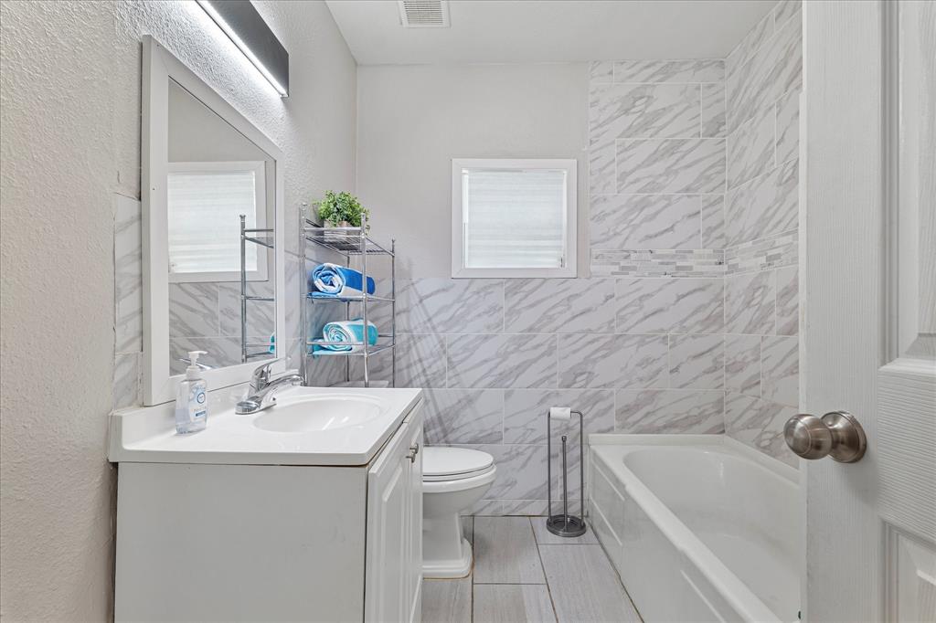 25 West Parnell Street Denison, TX 75020 - Photo 14 of 16 a bathroom with a sink a toilet and shower