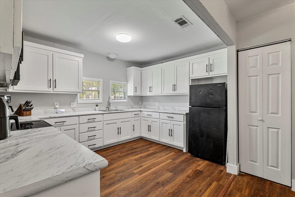 25 West Parnell Street Denison, TX 75020 - Photo 6 of 16 a kitchen with a refrigerator stove and white cabinets