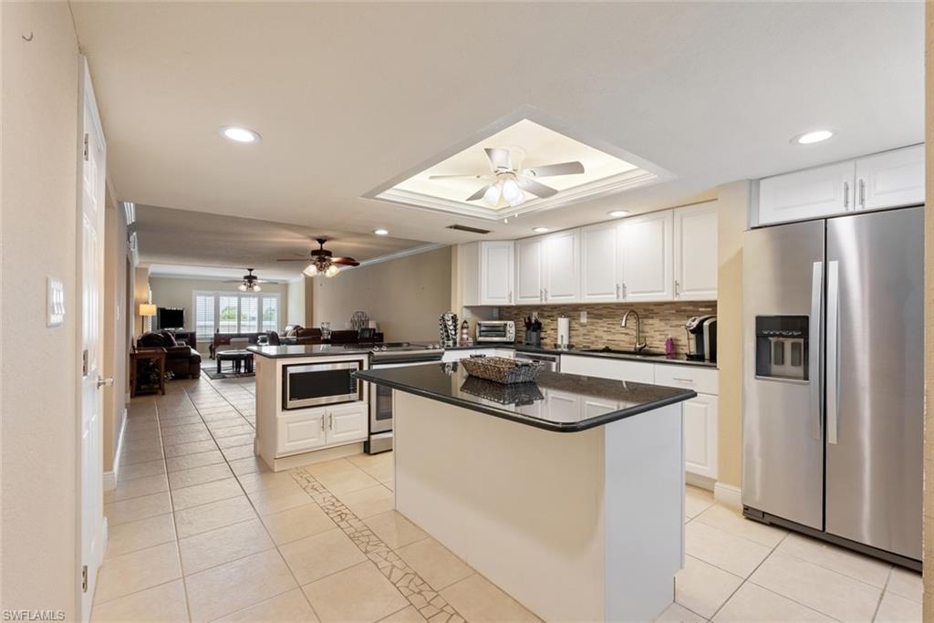 2264 Winkler Avenue, Unit 202 Fort Myers, FL 33901 - Photo 1 of 21 Kitchen featuring ceiling fan, stainless steel appliances, a center island, sink, and white cabinetry