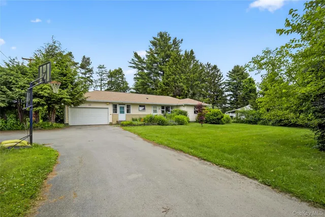 a front view of a house with a yard and trees