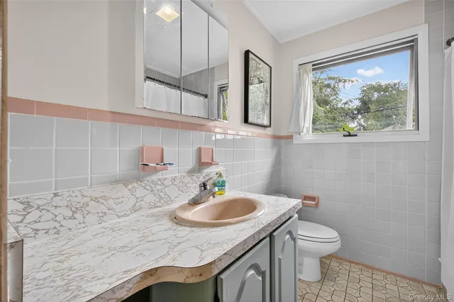 a bathroom with a sink a toilet and a mirror
