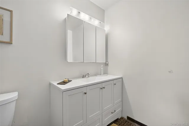 a bedroom with a bed a couch and a flat tv screen on the dresser