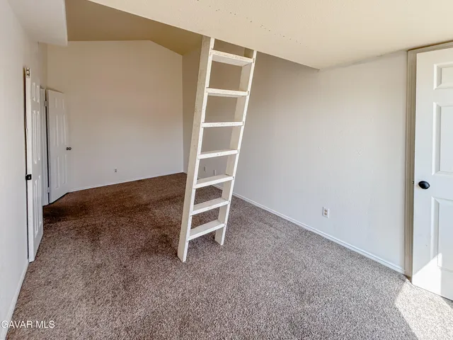 a view of an empty room with wooden floor and closet