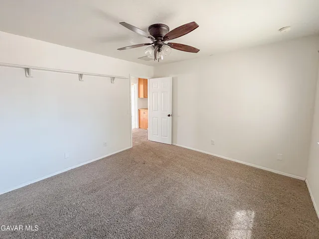 a view of a room with a ceiling fan and a ceiling fan