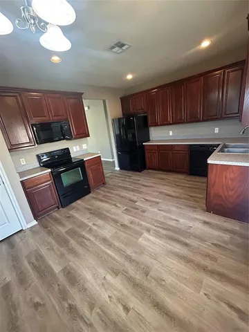 a kitchen with stainless steel appliances wooden cabinets and fireplace