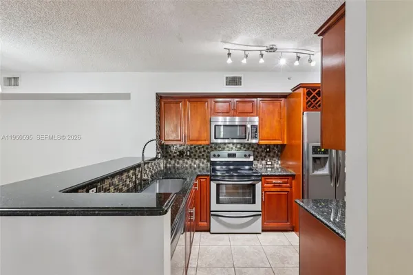 a kitchen with stainless steel appliances granite countertop a stove and a refrigerator