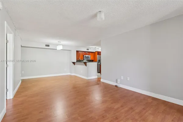 a view of a big room with wooden floor and a window