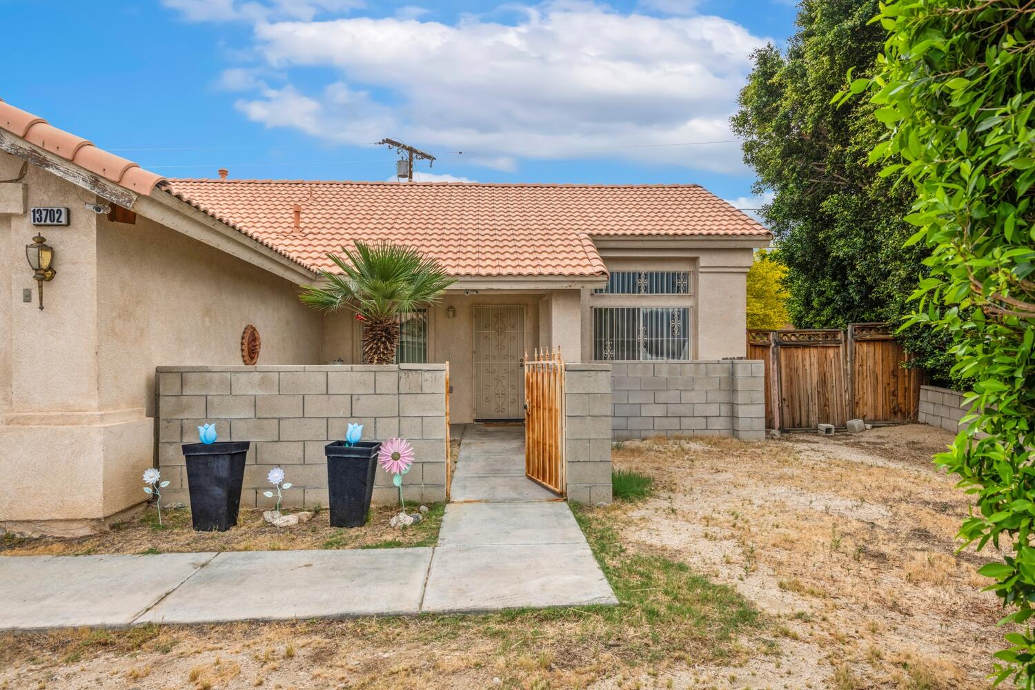 13702 Inaja Street Desert Hot Springs, CA 92240 - Photo 2 of 19 a front view of a house with garden