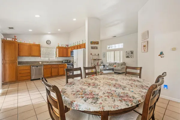 a living room with stainless steel appliances furniture a kitchen island dining table and chairs