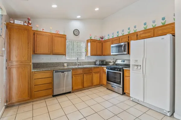 a kitchen with stainless steel appliances granite countertop a refrigerator and a stove top oven
