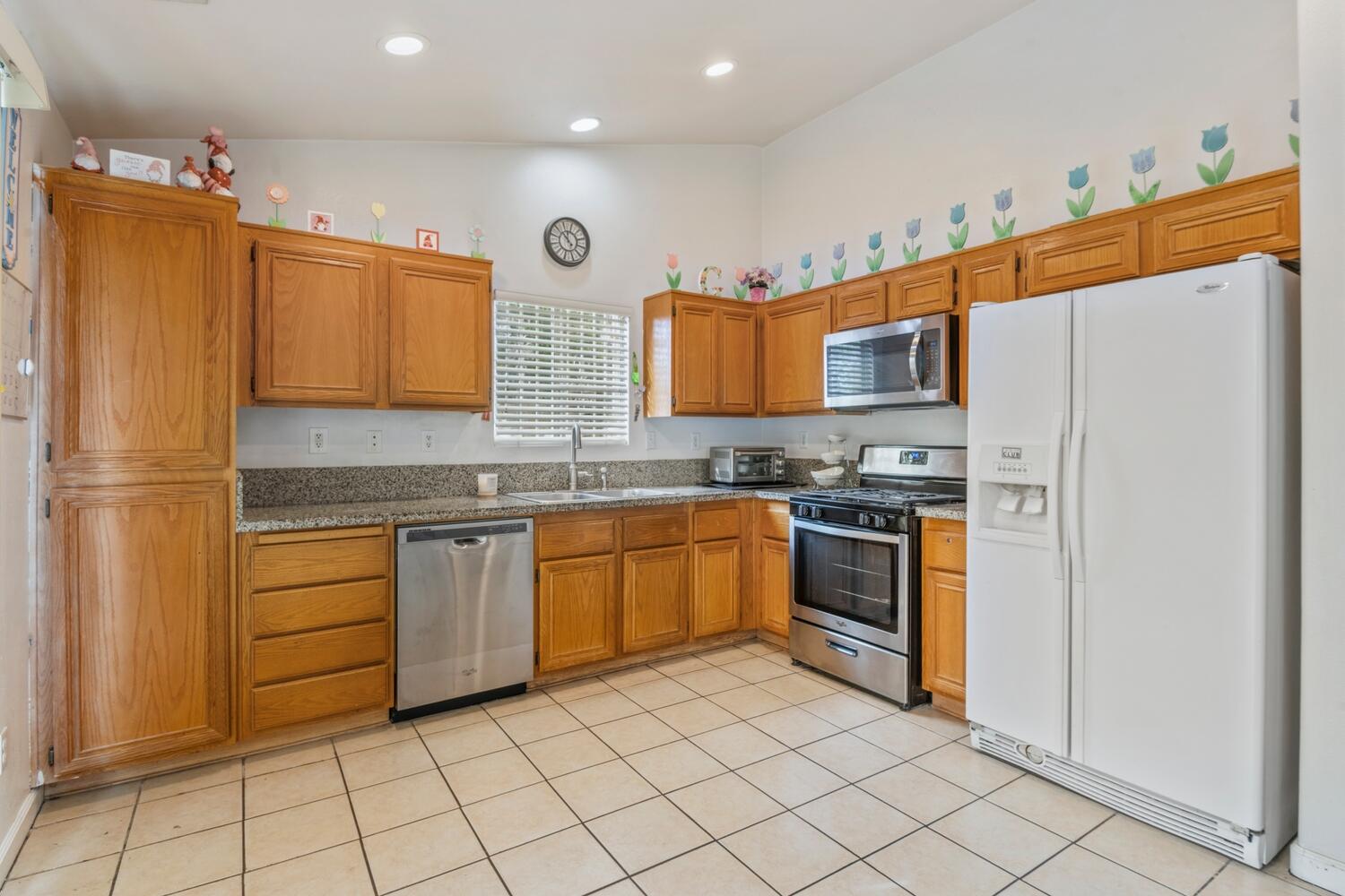 13702 Inaja Street Desert Hot Springs, CA 92240 - Photo 8 of 19 a kitchen with stainless steel appliances granite countertop a refrigerator and a stove top oven