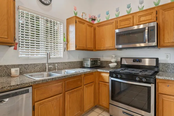 a kitchen with stainless steel appliances granite countertop a sink and a microwave