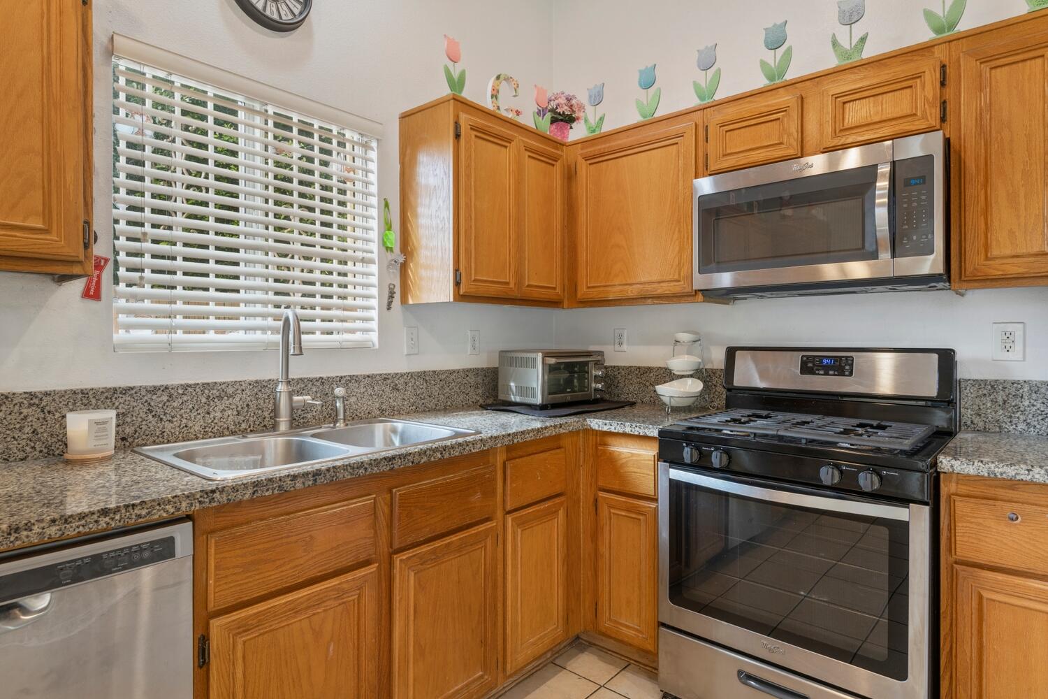 13702 Inaja Street Desert Hot Springs, CA 92240 - Photo 9 of 19 a kitchen with stainless steel appliances granite countertop a sink and a microwave