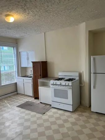 a kitchen with a stove top oven and refrigerator